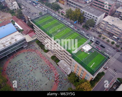 In this aerial view, children play football at a football stadium built on the rooftop of the Primary School Attached to Shandong Normal University in