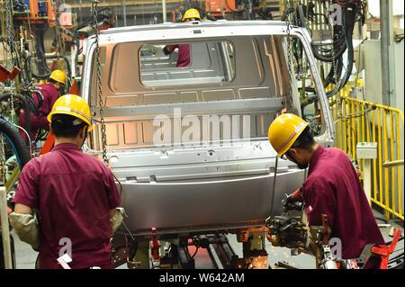 --FILE--Chinese workers assemble a truck on the assembly line at the ...