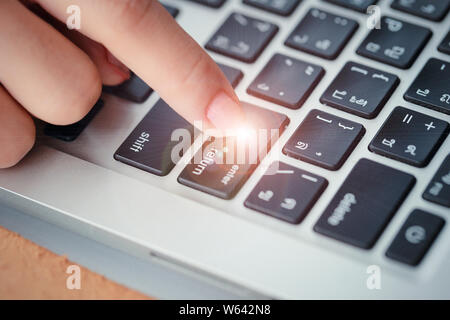human hand press enter or confirm button on computer keyboard Stock Photo