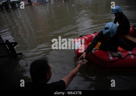 Rescuers evacuate local residents by inflatable life boat from flooded ...