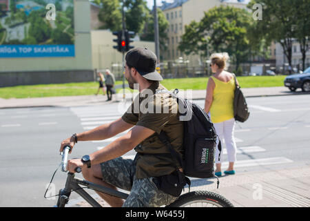 City Riga, Latvian Republic. Cyclist stopped at red traffic light.2019. 24. July. Travel photo. Stock Photo