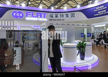 --FILE--People visit the stand of Flat Glass Group Co., Ltd. during an expo in Shanghai, China, 21 April 2018.   Shares of photovoltaic firms rallied Stock Photo