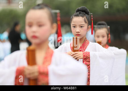 Students dressed in traditional costumes attend the autumn sacrifice to Confucius at a primary school in Hengyang city, central China's Hunan province Stock Photo