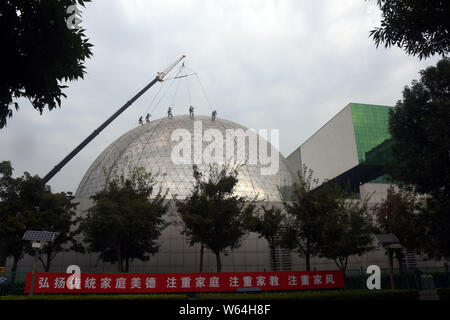 'Spider-Man' workers do cleaning on the dome of China Science and Technology Museum in Beijing, China, 11 September 2018. Stock Photo