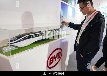 --FILE--A visitor looks at a model train of the 'Yungui' or the 'SkyRail' monorail system developed by Chinese new-energy vehicle manufacturer BYD dur Stock Photo