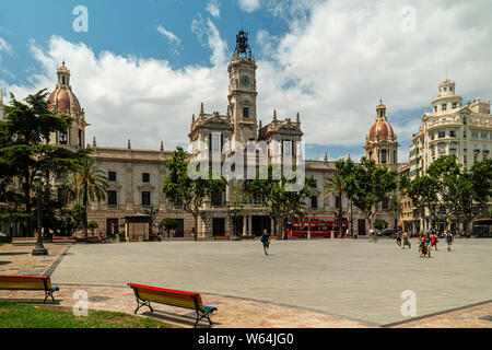 JULY 27, 2019 - VALENCIA, SPAIN. Valencia City Hall (18th century) with people walking across the plaza Stock Photo