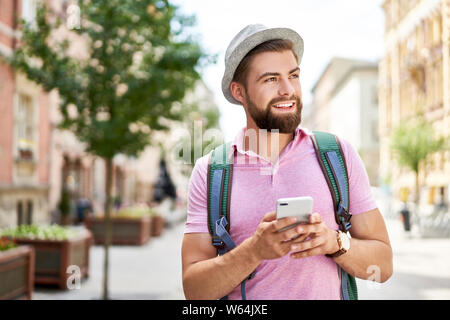 Man with backpack using phone during Europe trip Stock Photo