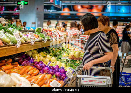 --FILE--Chinese customers shop for vegetables at a store of O2O fresh produce retailer Hemaxiansheng, also known as Hema Fresh Store, of Chinese e-com Stock Photo