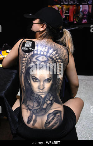 A visitor displays tattoos on her back during the Second Changchun International Tattoos Exhibition 2018 in Changchun city, northeast China's Jilin pr Stock Photo