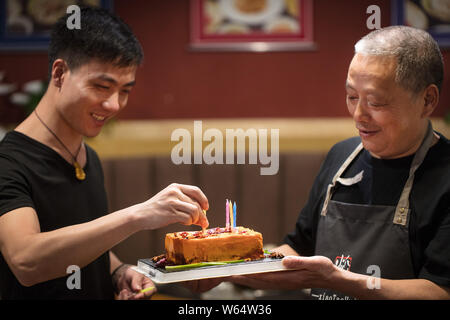 A Chinese man celebrates his father's birthday as he prepares a custom-made 'spicy hotpot birthday cake' featuring the shape of piquant chafing dish s Stock Photo