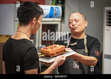 A Chinese man celebrates his father's birthday as he prepares a custom-made 'spicy hotpot birthday cake' featuring the shape of piquant chafing dish s Stock Photo