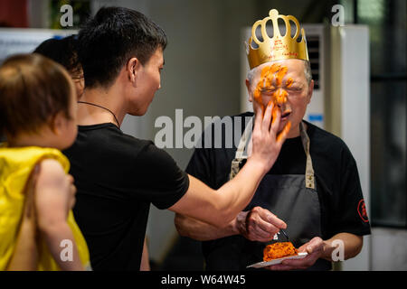 A Chinese man celebrates his father's birthday as he prepares a custom-made 'spicy hotpot birthday cake' featuring the shape of piquant chafing dish s Stock Photo