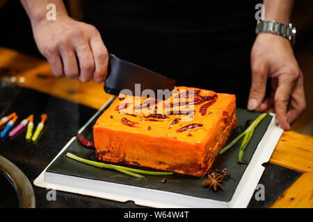 A Chinese man celebrates his father's birthday as he prepares a custom-made 'spicy hotpot birthday cake' featuring the shape of piquant chafing dish s Stock Photo