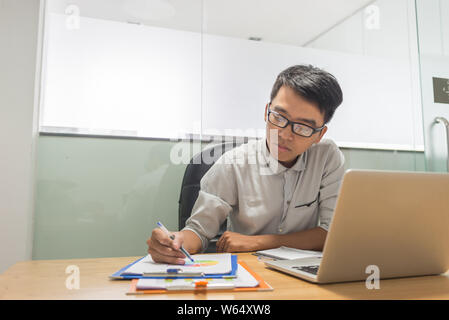 Serious businessman working on financial documents in the office Stock Photo