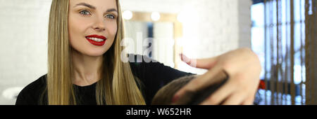 Young Woman Hairdresser Making Haircut with Comb Stock Photo