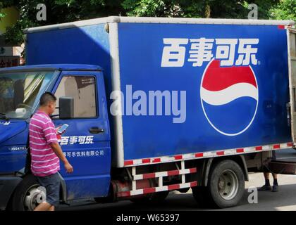 --FILE--A pedestrian walks past a delivery truck for Pepsi Cola in Yichang city, central China's Hubei province, 30 July 2013.   PepsiCo highlighted i Stock Photo