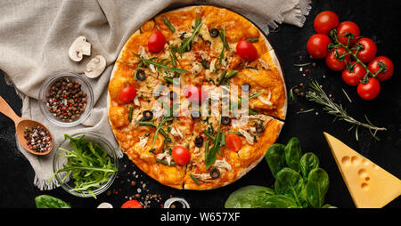 Pizza decorated with rocket salad and cherry tomatoes Stock Photo