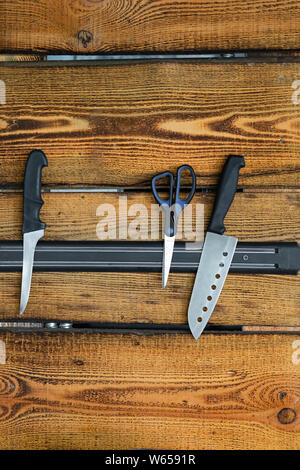 Magnetic knife holder on a wooden wall. Stock Photo