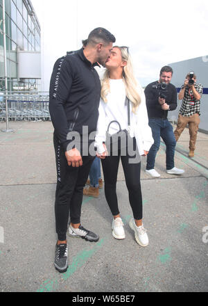 Love Island runners up Tommy Fury and Molly Mae Hague share a kiss as they arrive at Stansted Airport in Essex following the final of the reality TV show. Stock Photo