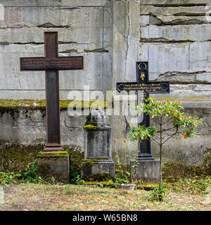 Two crosses on graves next to weathered wall in Berlin Cathedral Cemetery in Müllerstraße72/73, Wedding-Berlin. Berliner Dom Friedhof. Stock Photo