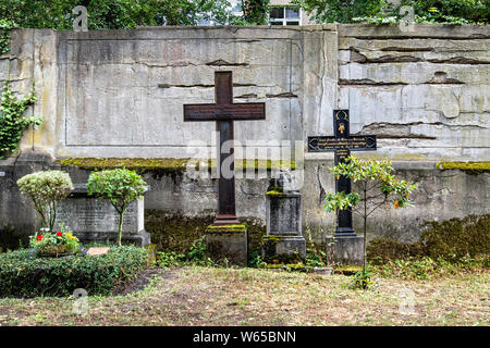 Two crosses on graves next to weathered wall in Berlin Cathedral Cemetery in Müllerstraße72/73, Wedding-Berlin. Berliner Dom Friedhof. Stock Photo