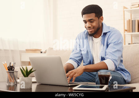 Millennial black man working on laptop in home office Stock Photo