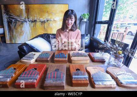Chinese music lover April Yang poses for photos with redesigned kalimbas, or thumb pianos, at a workshop in Jiaxing city, east China's Zhejiang provin Stock Photo