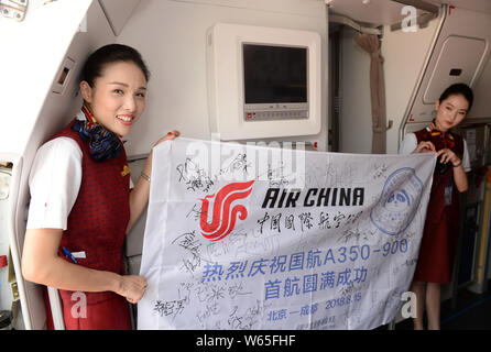 Flight attendants pose in a business-class cabin of an Airbus A350-900 jet plane of Air China after it arrived at the Chengdu Shuangliu International