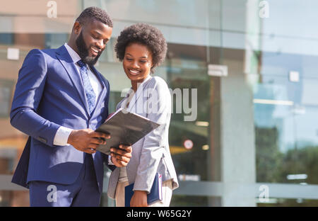 Couple of african american business partners working while standing outdoors Stock Photo