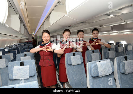 Flight attendants pose in a economy-class cabin of an Airbus A350-900 jet plane of Air China after it arrived at the Chengdu Shuangliu International A