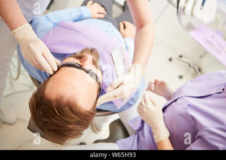 Patient at the dentist is prepared with a pair of protective goggles for the professional bleaching Stock Photo