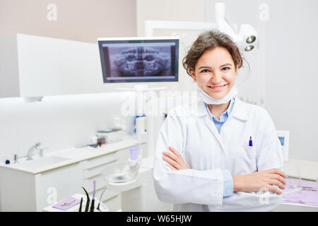 Smiling young dentist or dental assistant in training in the dentist office Stock Photo