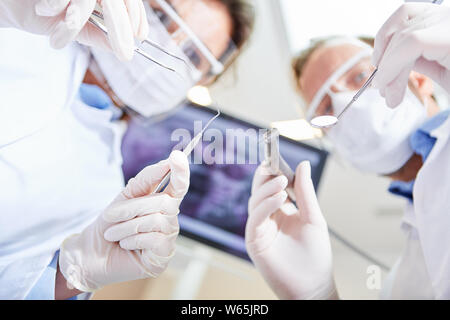 Two dentists as a team in an emergency operation in the oral surgery of a dental clinic Stock Photo
