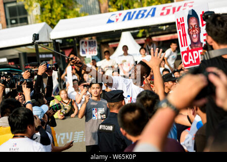 NBA star Clint Capela of Houston Rockets, center, takes selfies with fans during the NBA 5V5 Basketball Tournament in Chengdu city, southwest China's Stock Photo