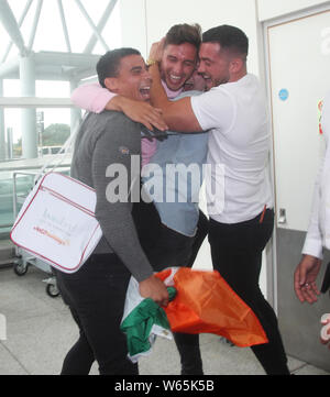 Family and friends greet Love Island winner Greg O'Shea (second left) as the Love Island contestants arrive at Stansted Airport in Essex following the final of the reality TV show. Stock Photo