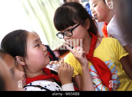 --FILE--A shortsighted child wearing glasses plays with classmates at a primary school in Guiyang city, southwest China's Guizhou province, 28 August Stock Photo