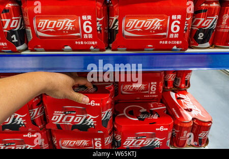 --FILE--A customer shops for tins of Coca-Cola coke at a supermarket in Shanghai, China, 12 June 2018.   US soda and beer lovers might want to start s Stock Photo