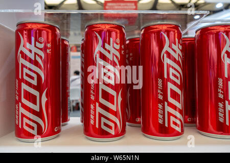 --FILE--Tins of Coca-Cola coke are displayed during an expo in Shanghai, China, 12 July 2018.   US soda and beer lovers might want to start stocking u Stock Photo