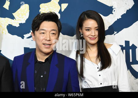 Taiwanese actress Shu Qi, right, and Chinese actor and director Huang Bo pose as they arrive on the red carpet during the premiere event for the new m Stock Photo