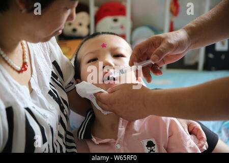 Chinese care worker Zhang Xia looks after the 7-year-old boy Peng Peng who was seriously injured due to his stepmother's cruel treatment at a hospital Stock Photo