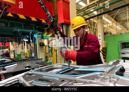 --FILE--A Chinese worker assembles a truck on the assembly line at an ...