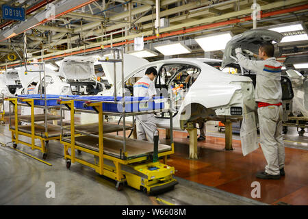 Chinese workers assemble Peugeot 508 on the assembly line at an auto ...