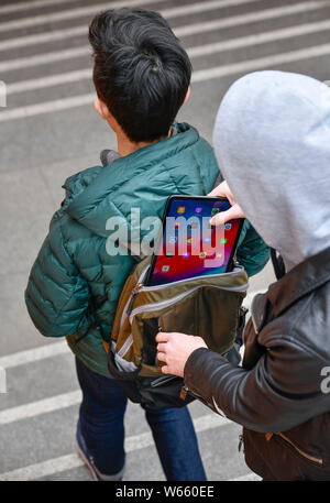 Diebstahl eines Tablets aus einem Rucksack, Strassenkriminalitaet, gestelltes Foto Stock Photo
