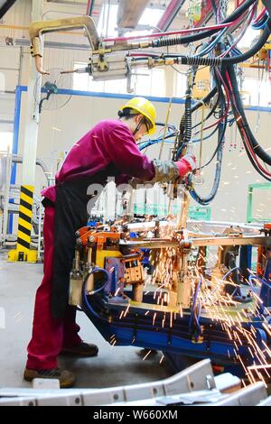 --FILE--A Chinese worker assembles a truck on the assembly line at an ...