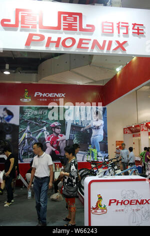 --FILE--People visit the stand of bicycle maker Shanghai Phoenix during an exhibition in Shanghai, China, 26 September 2014.    Bike manufacturers' in Stock Photo