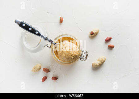 Peanut paste in glass gar. Healthy nutrition concept. View from above. Stock Photo
