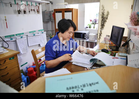 Chinese dormitory keeper Tang Xingfang, who has written six novels in the past six years, works at a dormitory building in the campus of Hangzhou Dian Stock Photo