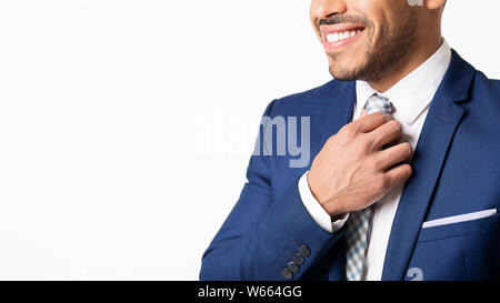 Hispanic Business Man Straightens His Tie On White Background, Cropped Stock Photo