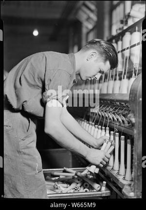 High Point, North Carolina - Textiles. Pickett Yarn Mill. Doffer in action - trying to portray doffer personality Stock Photo