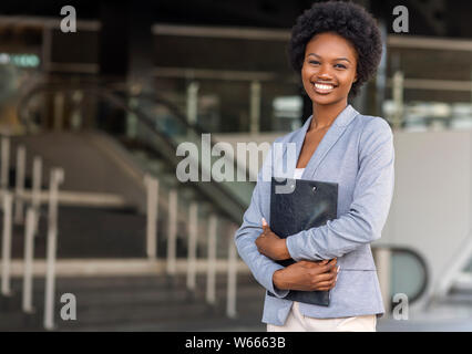 Female African American job seeker keeping a folder with CV Stock Photo